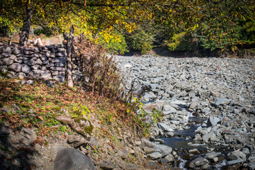 Natural hand made fence made of wooden tree brenches. Close up view of village fence with moss on wooden surface.