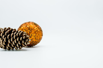 Cone pine and orange christmas tree ball on white.