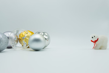 Silver, transparent and golden christmas balls on white background with polar bear toy.