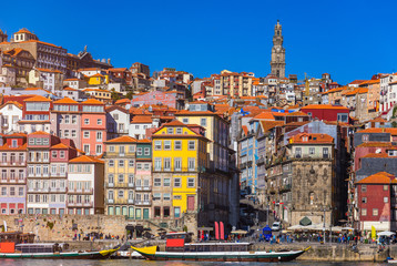 Fototapeta na wymiar Colorful houses of Porto Ribeira, traditional facades, old multi-colored houses with red roof tiles on the embankment in the city of Porto, Portugal