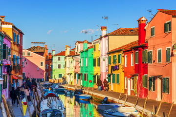 Fototapeta na wymiar Lovely house facade and colorful walls in Burano, Venice. Burano island canal, colorful houses and boats, Venice landmark, Italy. Europe