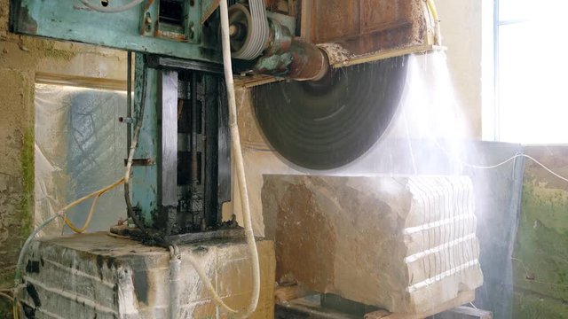 automatic machine with water supply is cutting cobble on the manufacturing. Stone processing