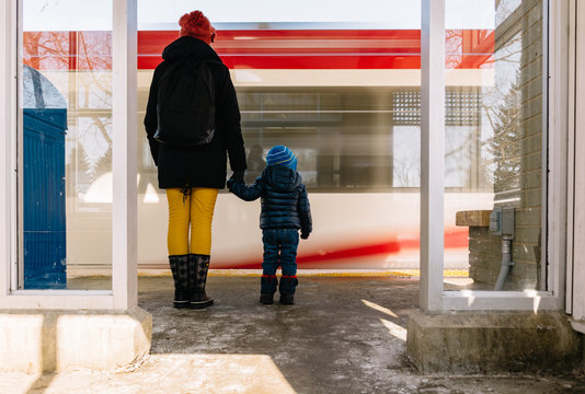 Woman and child holding hands waiting for the train