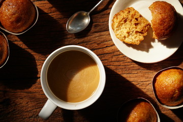 Hot coffee on wooden table, The best instant coffee served with banana cake. Porcelain coffee cup on table with dessert, Selective focus and free space for text. Industrial food and drink concept.