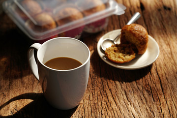 Hot coffee on wooden table, The best instant coffee served with banana cake. Porcelain coffee cup on table with dessert, Selective focus and free space for text. Industrial food and drink concept.