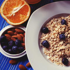 Breakfast with oatmeal and orange juice on blue wooden background