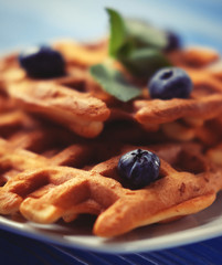 Homemade belgian waffles with fresh blueberry and raspberry over wooden background. Top view.