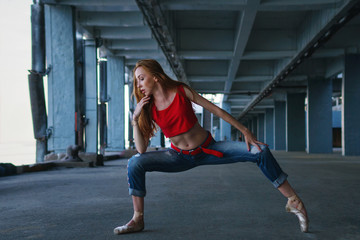 Fototapeta na wymiar Ballerina dancing in jeans, t-shirt and pointe. Street performance. Modern art. Thin girl dancing on tiptoe.
