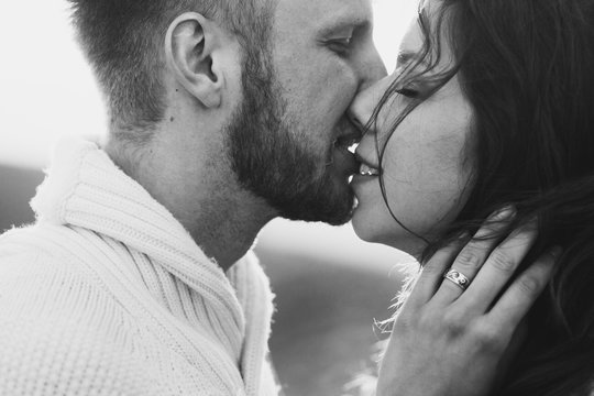 Close-up portrait of man and woman together, happy, looking at each other. Smiling, kissing and laughing. Black and white toning