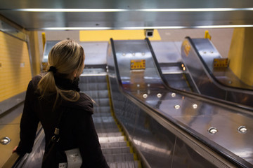 Woman going to work in the escalator at Subway Station