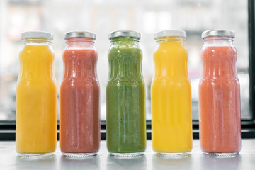 Fruit juices. Freshly squeezed fruit juices standing near the window in cafeteria early in the morning