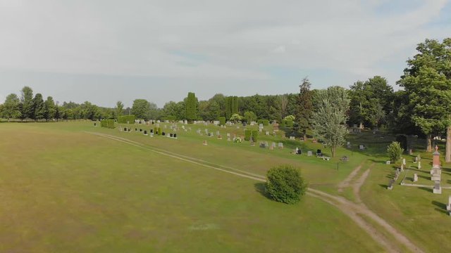 Aerial,  low flyover country cemetery, risin gup over trees, summer