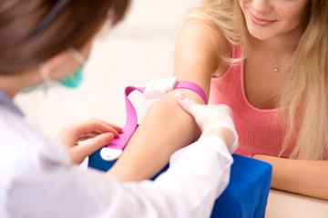 Young beautiful woman during blood test sampling procedure 