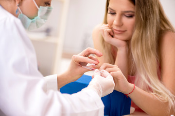 Obraz na płótnie Canvas Female doctor taking blood samples from finger
