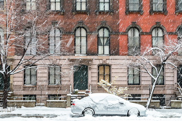 New York City winter street scene with snow covered car parked on Stuyvesant Street in the East...