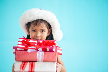 Cute asian child girl wearing santa hat and holding beautiful gift in hand on Christmas celebration