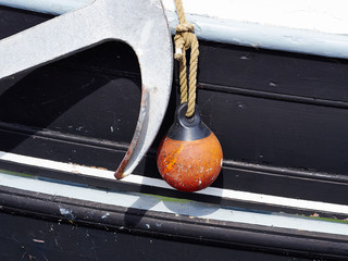 Boat side with protection fender and an anchor