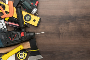 different construction tools on wooden background with copy space. diy construction tools on the brown table