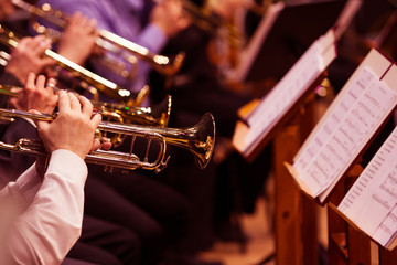Trumpets in the hands of the musicians in the orchestra 