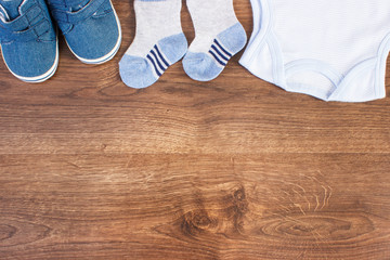 Baby shoes and clothing for newborn, expecting for kids concept, place for text