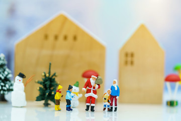 Miniature people: Santa Claus with Childrens playing fun with snow and christmas tree. Christmas...