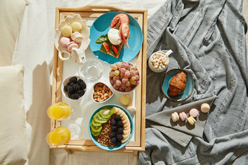 Overhead view of delicious breakfast in bed served on tray
