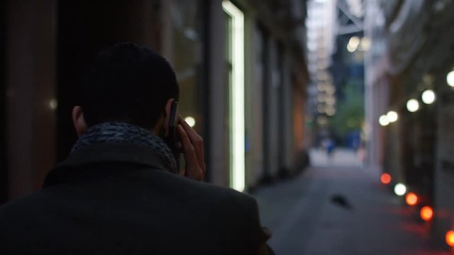 Camera follows a young city executive in an alley in the city, in slow motion