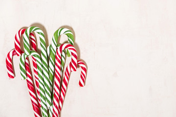 assortment of christmas sugar candies on white wooden background, top view
