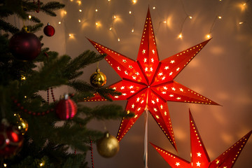 Red Christmas star. Christmas cozy home interior decoration, two glowing stars-Christmas home decorations for the New year