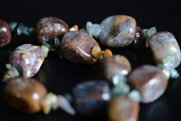 Fragment of a necklace from a natural stone on a dark background close up