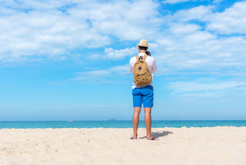 Summer Day. Happy smiling caucasian tourist asian young man holding camera for take a photo check in on the beach. Summer and Travel Concept..