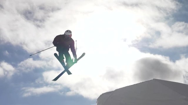 Slow motion - Freestyle skier jumping off springboard and doing a spin