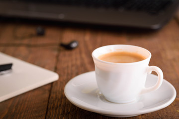  Laptop (notebook) mobile phone (smartphone) and notepad with pen on old wooden table. Work place modern.Cup of coffee