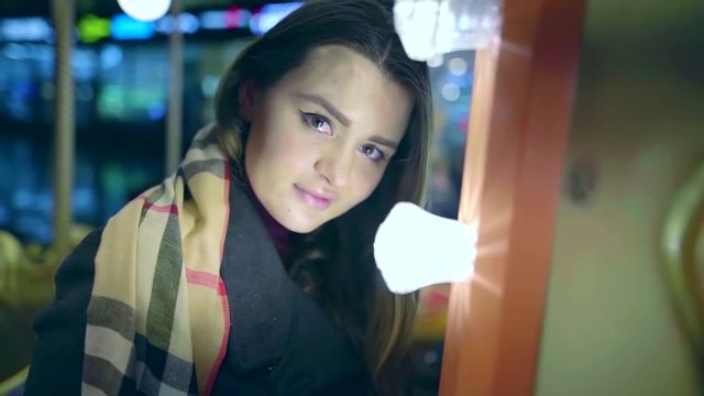 portrait of a young pretty girl on the street walking at night in an amusement Park