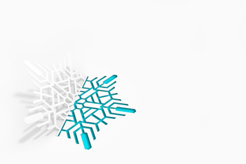 Carved paper snowflake folded in half, bent, casts a beautiful shadow on a white background 3d...