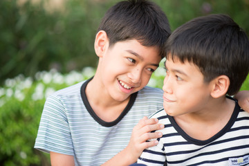 Asain Sibling boy sit togehter in the park