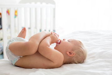 Young mom, changing baby diaper after bath