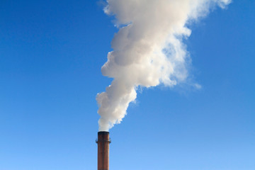 white pure smoke flies from the pipe to the blue sky