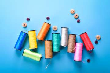  Colored thread coils on blue background, sewing, place for text
