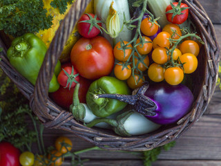 Fresh vegetables in a basket on a rustic wooden table with space for text.