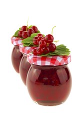 currant jam.three jars of berry jam in a row.red currant jam and red currant  isolated on white background. Berry season. Currant crop	