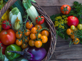 Fresh vegetables in a basket on a rustic wooden table with space for text.