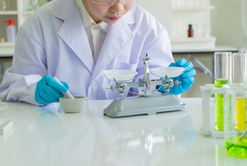 Female scientist or Health care researchers with equipment and science experiments while weighing the sample something or other on the scales. laboratory conducting experiments and analysis concept