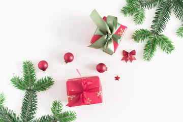 Christmas elegant composition. Xmas red gifts and decorations, green fir tree branches on white background. Christmas, New Year, winter concept. Flat lay, top view, copy space 
