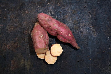 Fototapeta Bataty. Słodkie ziemniaki na ciemnym tle. obraz