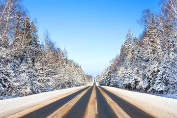 winter landscape with asphalt road and forest