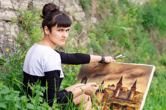 A young artist student paints a picture.