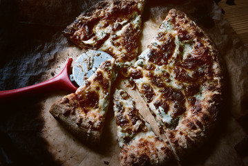 The last pieces of pizza, close-up. Delicious pizza with cheese and cherry tomatoes on wooden table, close-up.