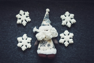 Santa Claus dolls and Christmas decorations snowflakes on background