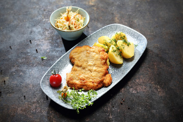 Kotlet smażony w panierce, ziemniaki z wody, surówka z białej kapusty.